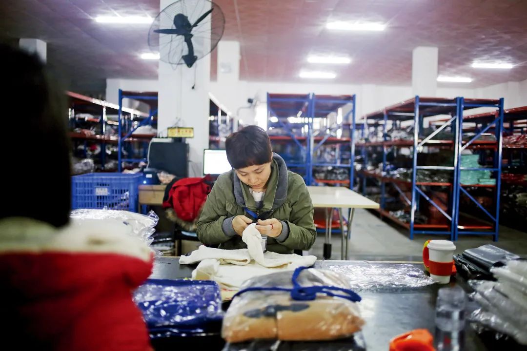 广州市白云区一家服装平台内，工作人员在打包跨境电商订单产品。图/视觉中国
