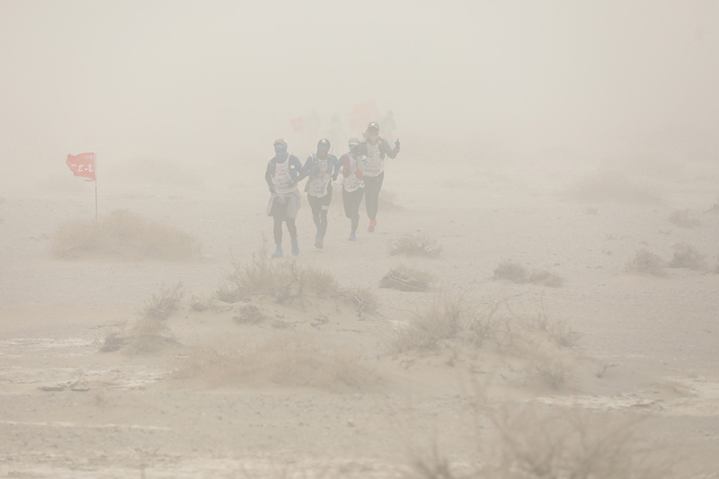 5月3日，队员们距离黄谷驿营地五公里处遭遇极端沙尘暴天气，能见度大约百米左右，参赛队员随风而行。   摄影记者/张健、任玉明