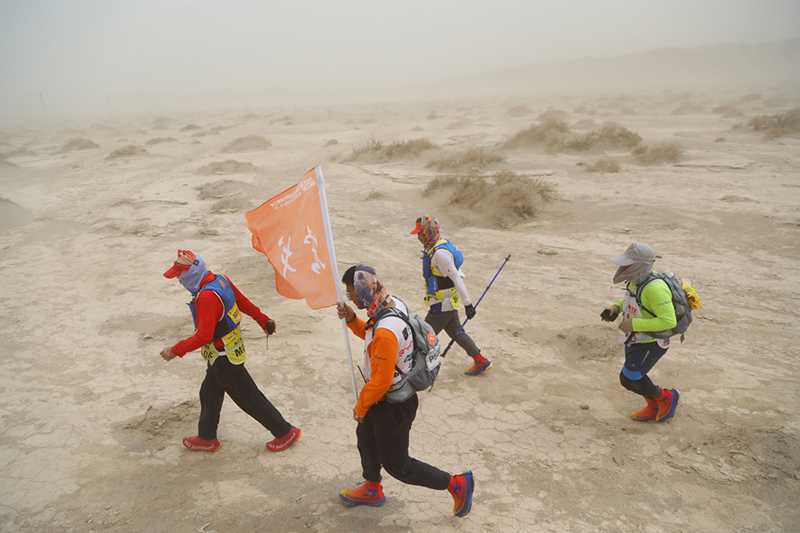 戈壁挑战赛盐碱地路段，参赛队员互助前行。   摄影记者/张健、任玉明