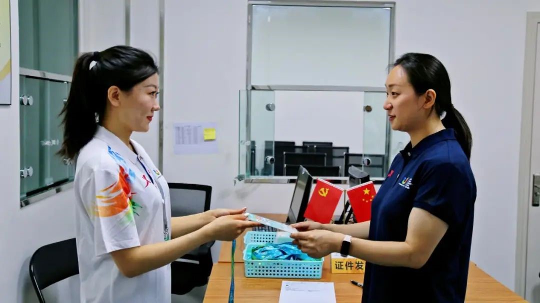 周智俐（右一）在成都大运会组委会注册中心领取注册卡