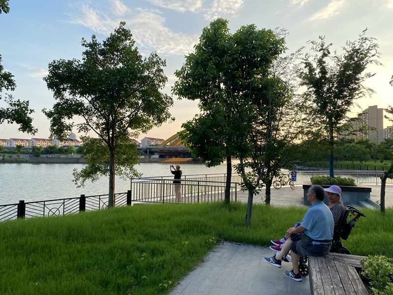 赵家沟、曹家沟滨水区域非常宜人，有人在拍摄张杨北路桥的晚霞，老年人在水边坐着聊天