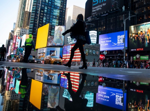 在美国纽约，一名女士经过时报广场附近。新华社资料图