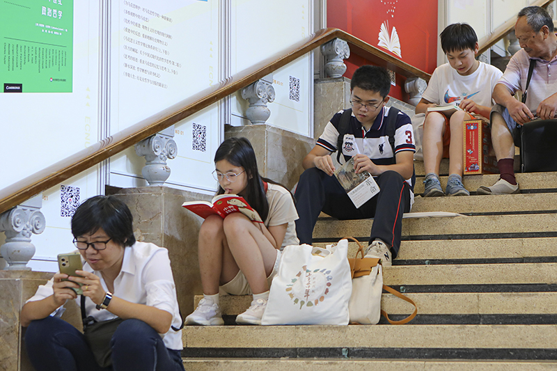 坐在台阶上看书、休息的读者
                            新华社图