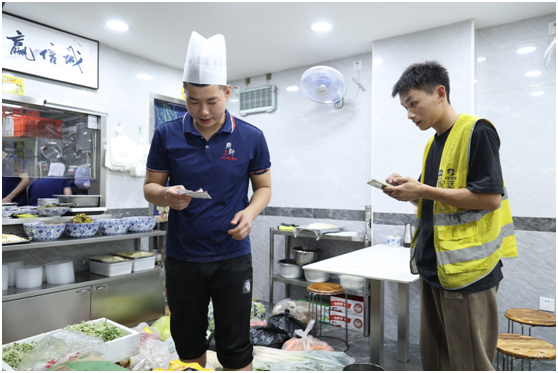 图为食材配送员和店员核对线上订单 摄影/朱冲