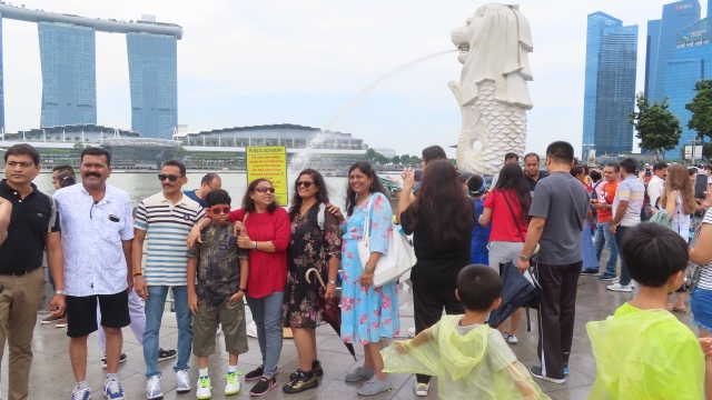 在新加坡地标“鱼尾狮”前拍照留念的印度游客（来源：第一财经记者摄）