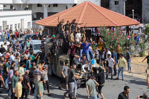 10月7日，在加沙城，巴勒斯坦人登上一辆以色列军用车辆。文内配图均自新华社