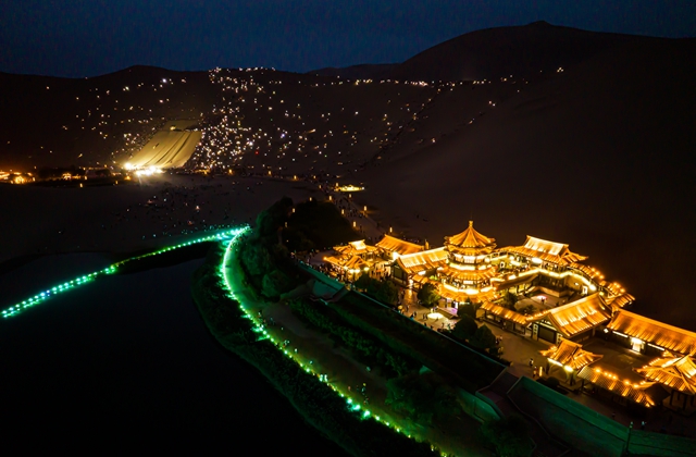 8月8日夜，游客在敦煌鸣沙山上亮起手机参加演唱会（无人机照片）。新华社