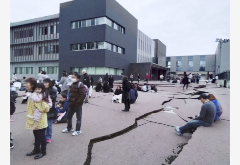 1月1日，在日本石川县轮岛市，人们站在被地震破坏的地面上。新华社