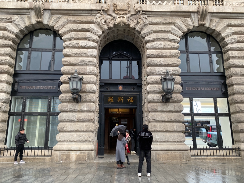不断有游客在外贸大楼门口拍照留念。大楼东面正门的门头是“罗斯福”，一层还有一家汽车展示店。   摄影/佟鑫